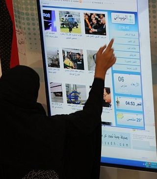 سعودية تقرأ على اللوح الإلكتروني