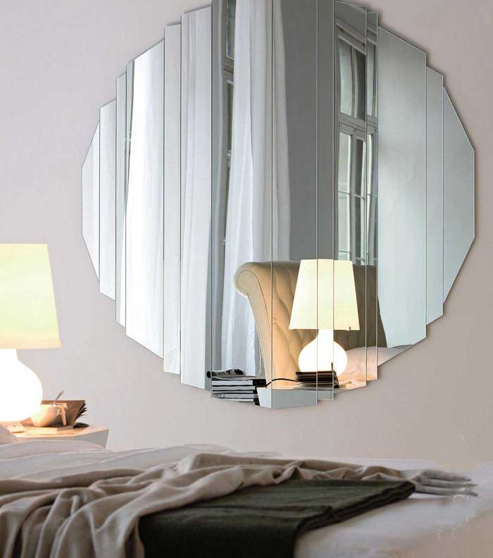 مرآة دائرية ومزخرفة الجوانب تعطي غرفة النوم مساحة أوسع