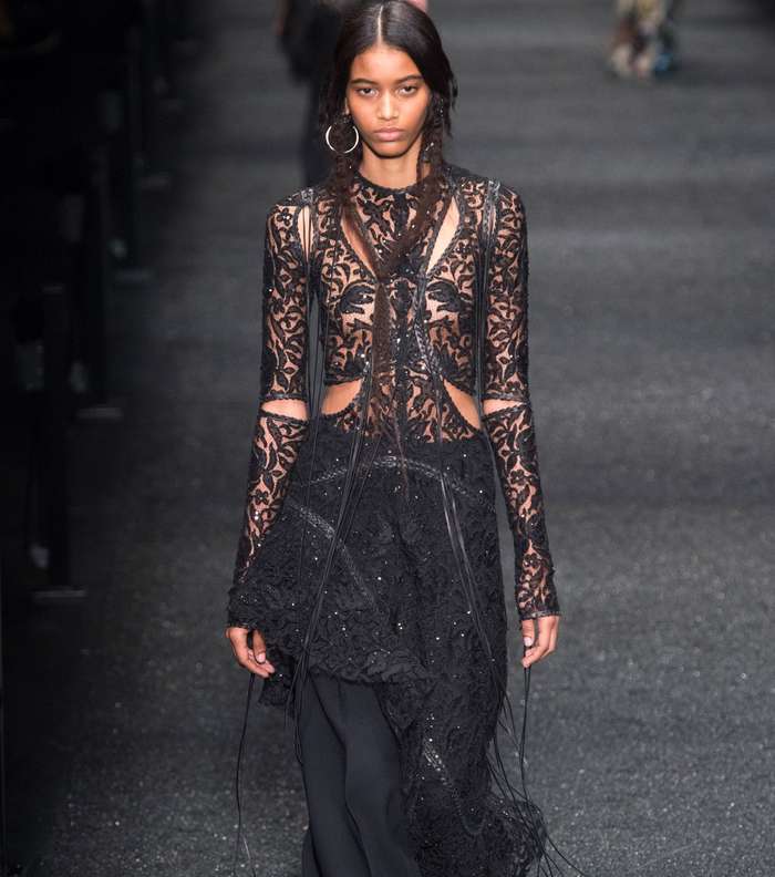 السروال الرسمي الواسع مع التوب الشفافة بقصة الـ cut out الطويلة فوقه من الكسندر ماكوين لشتاء 2018