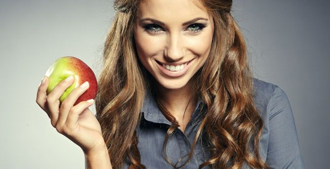 امرأة تتناول التفاح