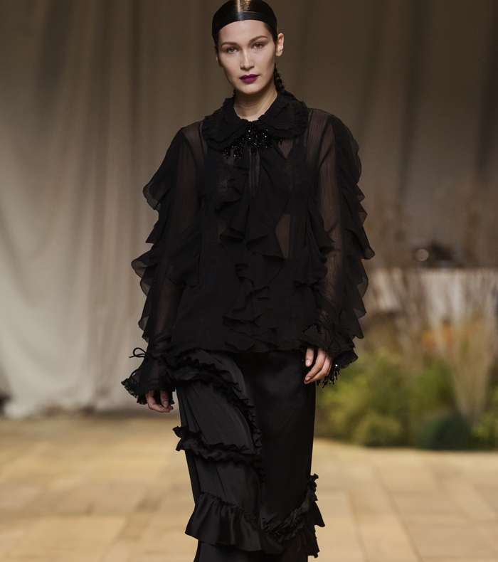 بيلا حديد بتنورة من الكشاكش مع قميص شفاف مزين بالكشاكش في عرض H&M Studio لصيف 2017