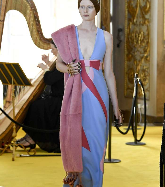 الفستان بالطول الذي يصل حد الكاحل مع خطوط بالوان مختلفة وشال فرو على كتف واحد من غوتشي كروز 2018