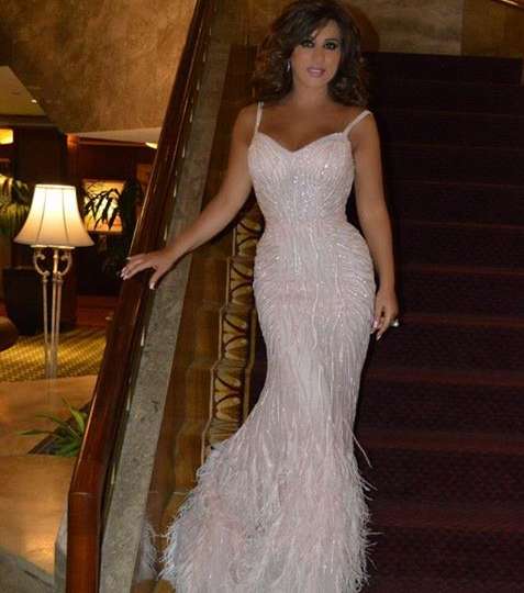 نجوى تجمع بين الترتر الناعم والريش في فستانها الزهري