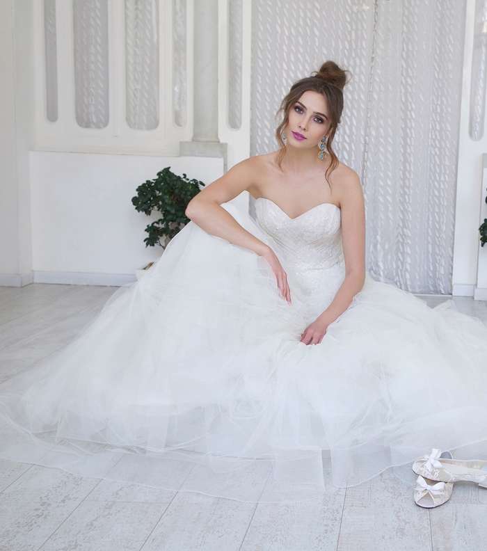 عروس Esposa العصريّة بثوبها والباليرينا الراكنة إلى جانبها