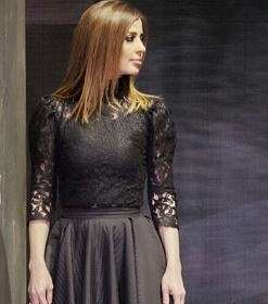 وفاء الكلاني تعتمد موضة الفستان الاسود بقصة التنورة الواسعة المثنية مع الدانتيل من الاعلى