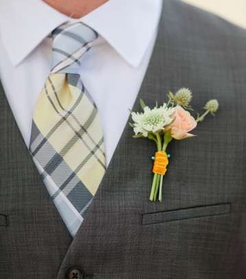 ربطة العنق ذات الرسومات المربّعة تنسجم مع الزهور الناعمة ذات الألوان الهادئة، والأعشاب الخضراء الصغيرة. 