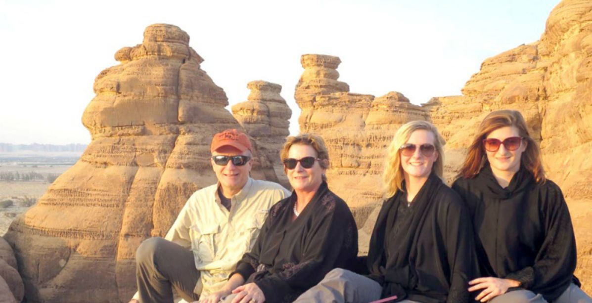 سياح أجانب يلتقطون صورة في محافظة العلا