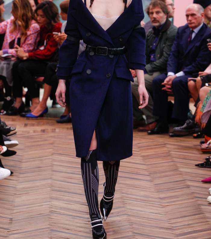 الفستان باسلوب معطف الترنش ولكن بقصة الـ Off Shoulders مع الشق الامامي من مجموعة برادا Resort 2018