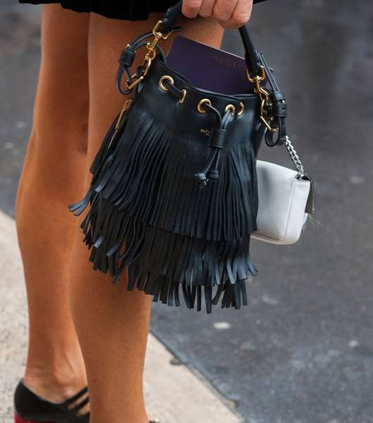 من شوارع الموضة، الفاشينيستا يعتمدن موضة ارتداء الحقيبتين في الاطلالة الواحدة