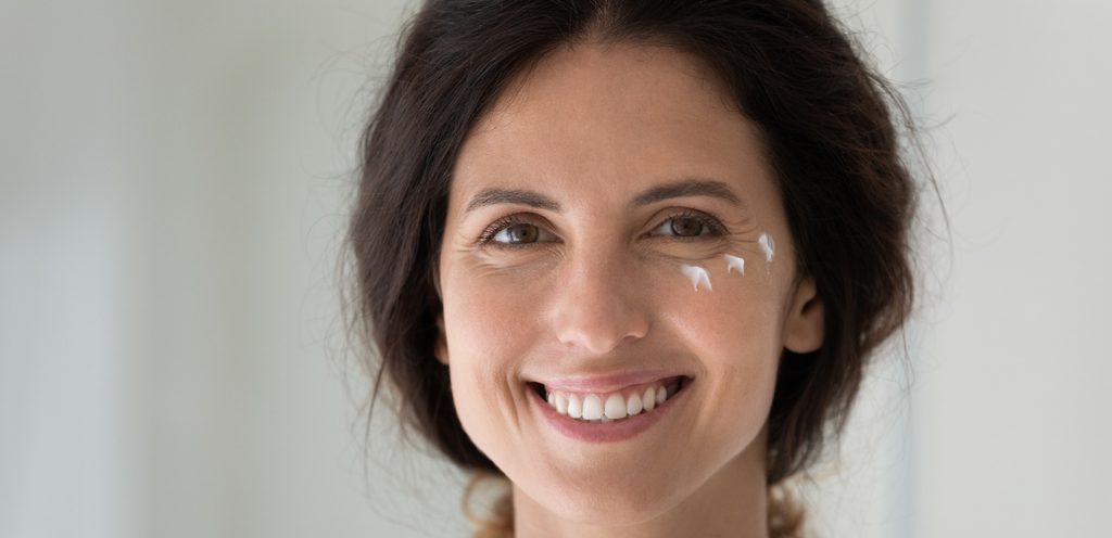 امرأة تضع الكريم تحت العين لعلاج الهالات السوداء