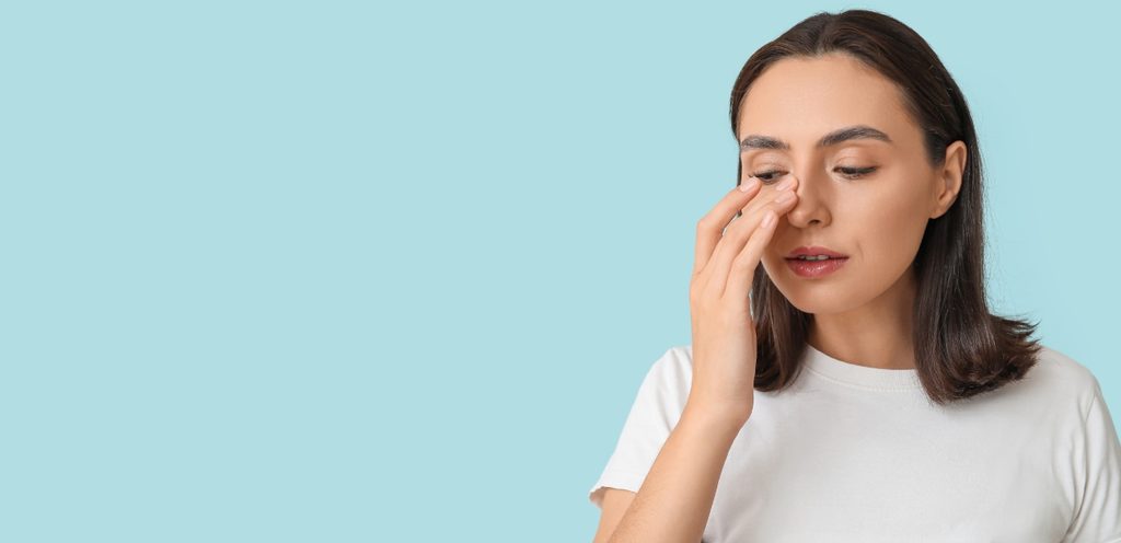 امرأة تلمس أنفها